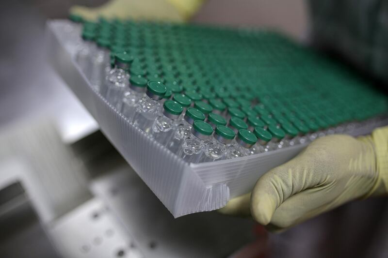 An employees handles vials of Covishield, the local name for the Covid-19 vaccine developed by AstraZeneca Plc. and the University of Oxford, on the production of line at the Serum Institute of India Ltd. Hadaspar plant in Pune, Maharashtra, India, on Friday, Jan. 22, 2021. Serum, which is the world's largest vaccine maker by volume, has an agreement with AstraZeneca to produce at least a billion doses. Photographer: Dhiraj Singh/Bloomberg