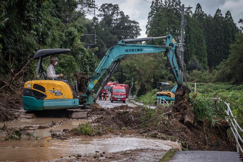 Heavy machinery is used to clears debris and mud from a road in Mimata. AFP