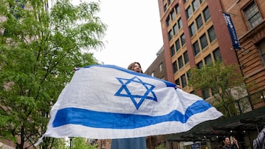A woman holds an Israeli flag outside of Baruch College in Manhattan, New York City. AFP