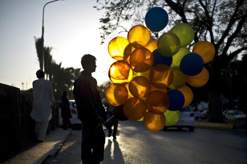 Tayyeb Younis, 16, stands on a roadside outside a shopping center on January 27, 2014, hoping to sell his balloons, in Islamabad, Pakistan. Muhammed Muheisen / AP photo