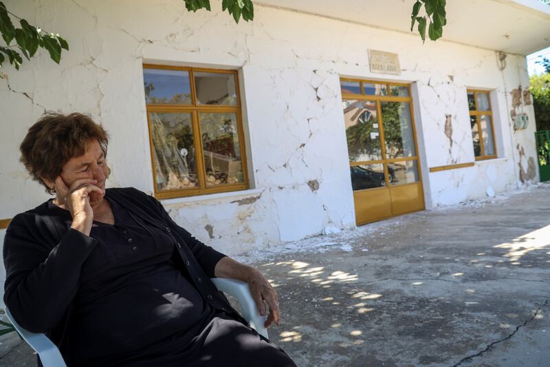 A woman sits outside a damaged building in Roussochoria following Monday's earthquake. Photo: Reuters