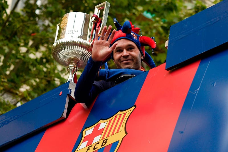 Andres Iniesta waves to the crowds from the top of the bus. Lluis Gene / AFP