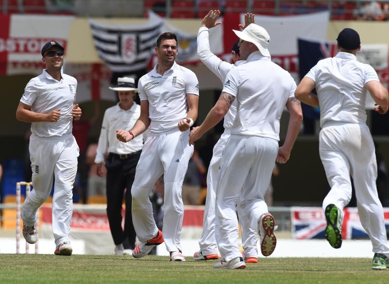 English fast bowler James Anderson (2nd L) celebrates after equaling the highest English wicket taker record with 383 after taking the wicket of Marlon Samuels for 23 with a catch by James Tredwell on day five of the first cricket Test match between West Indies and England at the Sir Vivian Richards Stadium in St John's, Antigua on April 17, 2015.  Anderson has taken the record from previous holder Ian Botham on 383.         AFP PHOTO/ MARK RALSTON (Photo by MARK RALSTON / AFP)