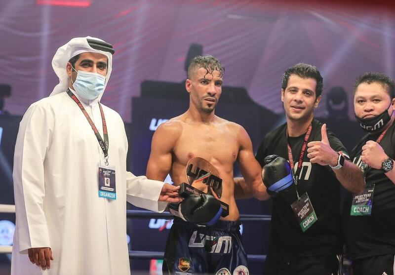 Brad Stanton receives his award from Tareq Al Muhairi after his disqualification win at Muaythai Fight Night Abu Dhabi. Courtesy UAE Muaythai and Kickboxing Federation