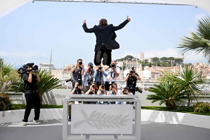 French actor Vincent Macaigne leaps from the podium during a photocall for the film ‘Chronique d'une Liaison Passagere’ (Diary of a Fleeting Affair) at the 75th Cannes Film Festival in southern France. AFP
