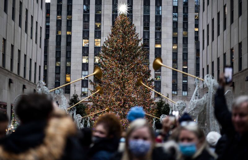 Tourists gather near the Christmas tree in Rockefeller Center in New York, n December 2. EPA