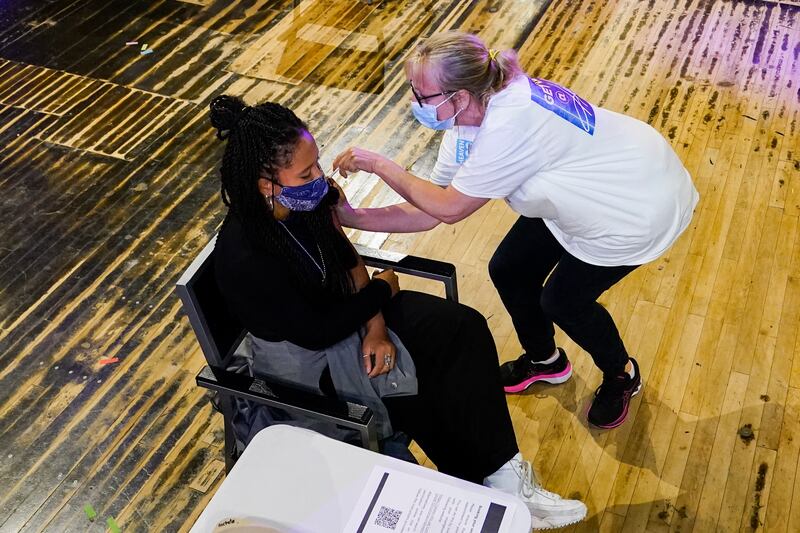 A patient receives a PfizerBioNTech shot at a pop-up vaccination centre in a London nightclub. AP