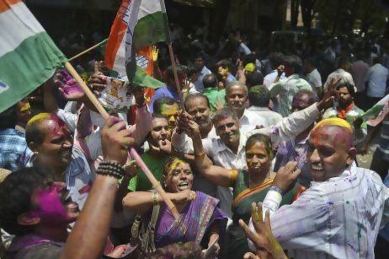 Congress party supporters celebrate outside a polling station after hearing their party had won the recent state elections in Bangalore.