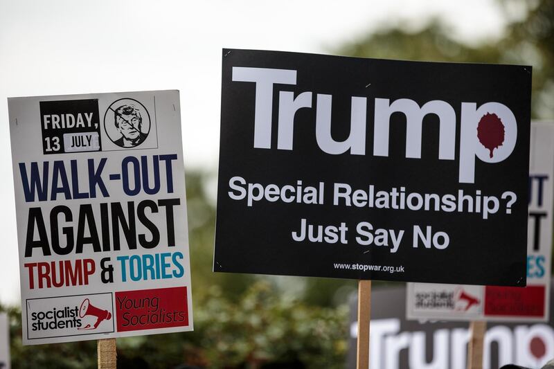 Protesters hold placards during a demonstration outside Winfield House. Getty Images