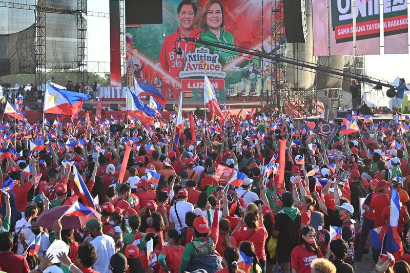 Supporters of Mr Marcos Jr and Ms Duterte wave flags during a campaign rally. AFP