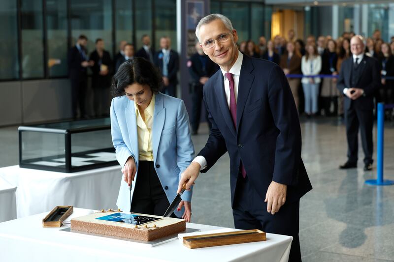 Nato Secretary General Jens Stoltenberg, right, and Belgium's Foreign Minister Hadja Lahbib cut a cake during a ceremony to mark the 75th anniversary of Nato at Nato headquarters in Brussels, Belgium. AP