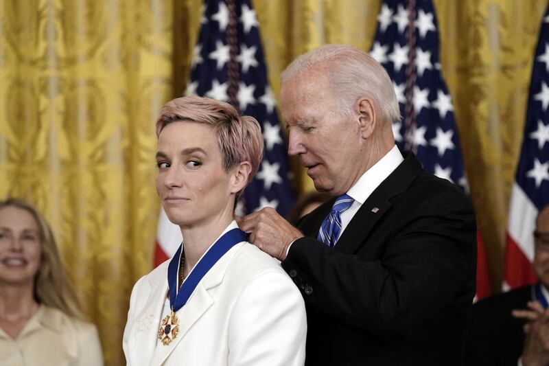 Mr Biden presents the award to footballer Megan Rapinoe, Olympic gold medalist and two-time Women's World Cup champion. UPI / Bloomberg 