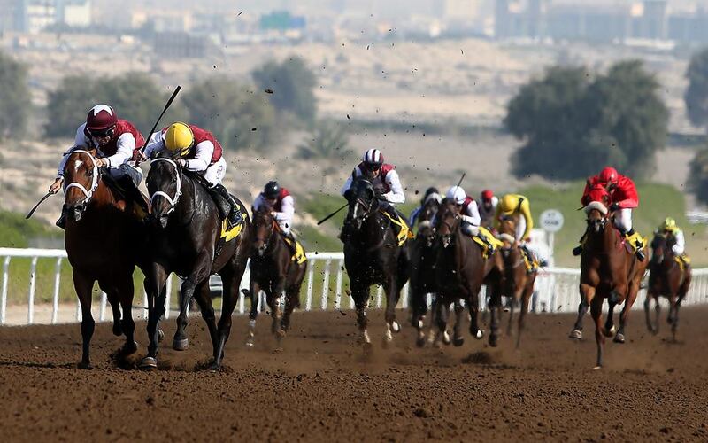 Pat Dobbs, second from left, guides Henry Clay to victory in the 1,800m handicap at Jebel Ali racecourse in Dubai on Friday. Pawan Singh / The National