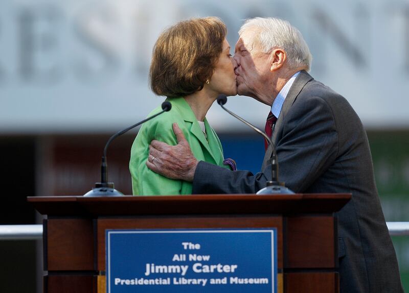 Ms Carter receives a kiss from her husband at the reopening ceremony for the newly redesigned Carter Presidential Library in Atlanta, in 2009. AP