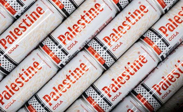 Palestine cola cans feature the distinctive Palestinian keffiyeh design and olive branches. Safad Food.