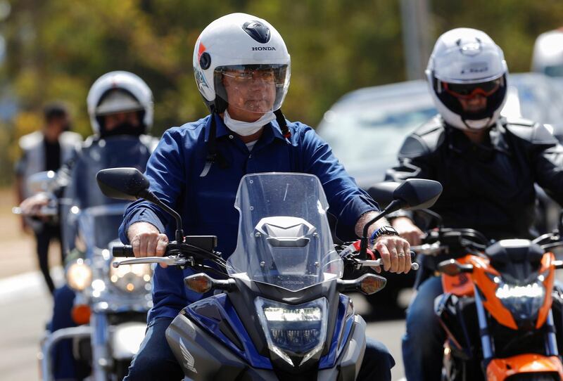 Brazil's President Jair Bolsonaro arrives at the Alvorada Palace on a motorcycle, amid the coronavirus disease (COVID-19) outbreak, in Brasilia Brazil July 25, 2020. REUTERS/Adriano Machado