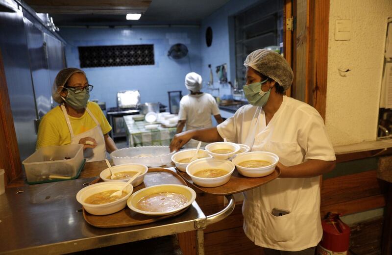 Caregivers serve soup in disposable dishes to avoid contamination at Sao Francisco de Assis shelter for the elderly in Sao Joao do Meriti, near Rio de Janeiro, Brazil. Reuters