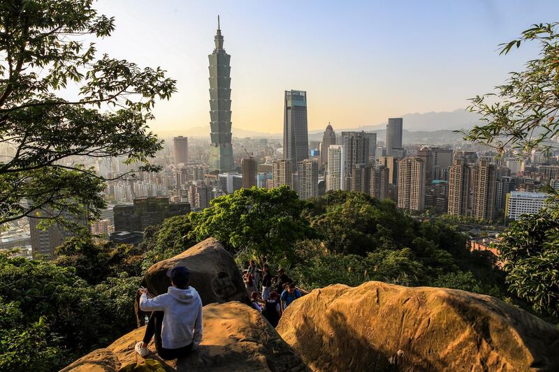 People climb a hill to enjoy the view of the Taipei 101 skyscraper in Taipei, Taiwan. Launched as the world's tallest building in 2004, the 508 -metre building with 101 floors is the eighth tallest building in the world. Ritchie B. Tongo / EPA
