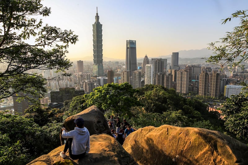 People climb a hill to enjoy the view of the Taipei 101 skyscraper in Taipei, Taiwan. Launched as the world's tallest building in 2004, the 508 -metre building with 101 floors is the eighth tallest building in the world. Ritchie B. Tongo / EPA
