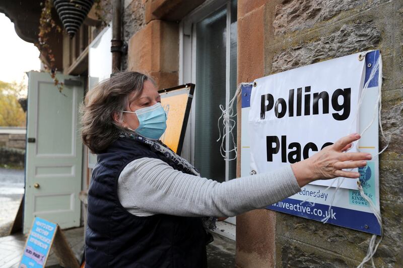 A woman puts up a sign at a polling station during local elections in Pitlochry, Scotland. Reuters