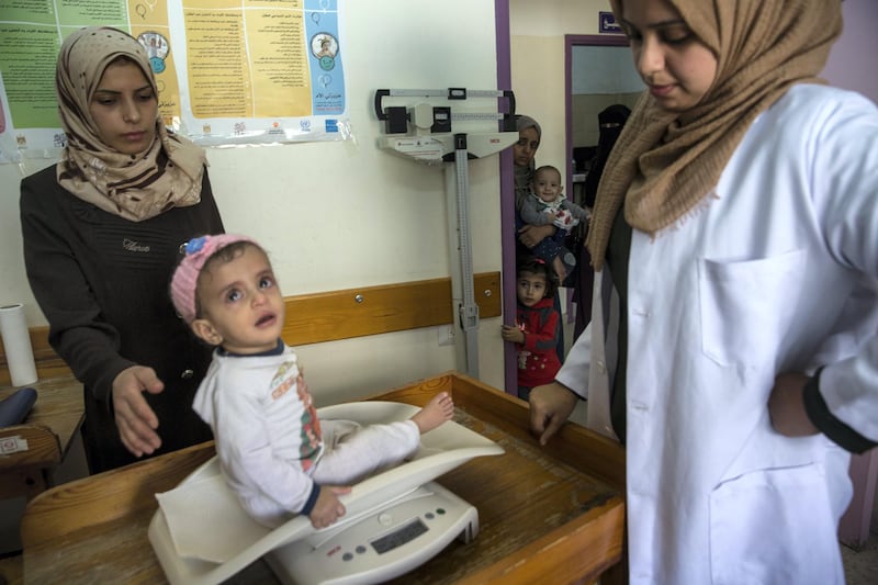Palestinian child Marah Eljama'al weight is recorded at the at the Ard El Insan clinic in Gaza City on October 28,2018.The child is suffering from severe malnutrition and moderate Anemia and weighs just 5.4 kilos (11.9 pounds), two kilos below the normal body weight of a child her age .Marah's chronic condition is increasingly plaguing Gazans, particularly women and children, eleven years into Gaza��s blockade.(Photo by Heidi Levine for The National).