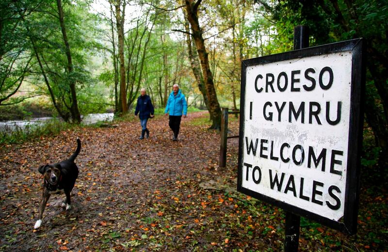 Walkers cross the border between England and Wales in Knighton, a town which sits on the border. AFP