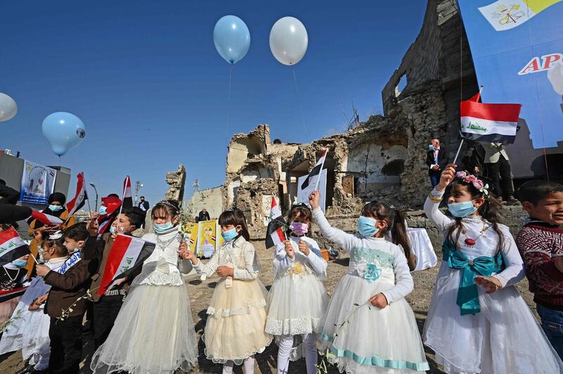 Iraqi children dressed in costumes wave national flags in the ruins of the Syriac Catholic Church of the Immaculate Conception. AFP