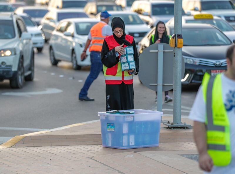 Abu Dhabi, United Arab Emirates, May 7, 2019.    Red Crescent volunteers and Abu Dhabi Police distribute food to motorists during iftar at the corner of 11th St. and 18th Sports City area.
Victor Besa/The National
Section:  NA
Reporter:  Haneen Dajani