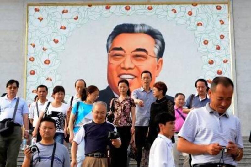 Chinese tourists leave after paying homage to a giant portrait of Kim Il-sung at a square in Rason city in North Korea. AFP PHOTO/ GOH CHAI HIN
