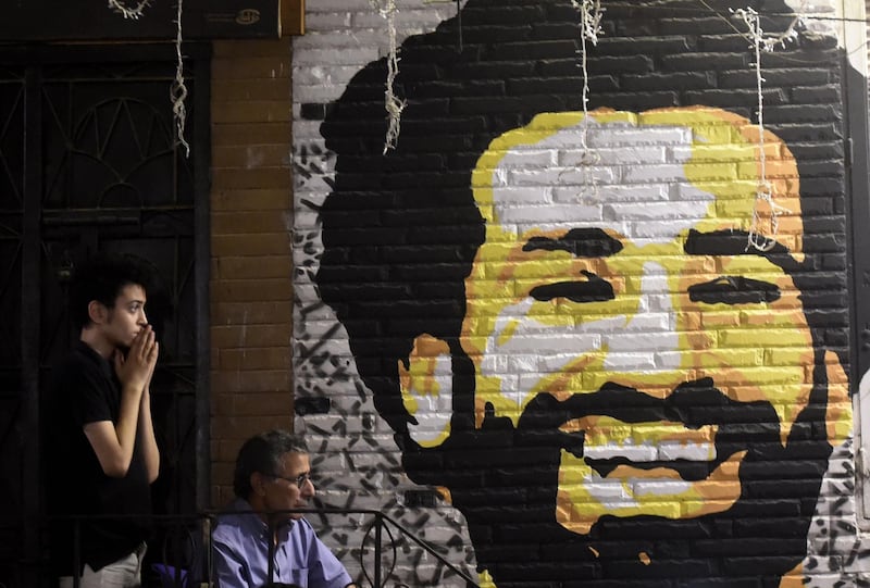TOPSHOT - A man reacts as he watches the the UEFA Champions League final football match, between Real Madrid and Liverpool, at a coffee shop in the Egyptian capital Cairo on May 26, 2018.
On the wall is a painting of Liverpool Egytian forward Mohamed Salah.    Liverpool suffered the loss of 44-goal top scorer Mohamed Salah to a shoulder injury on 31 minutes, after a tangle with Real defender Sergio Ramos. / AFP / KHALED DESOUKI
