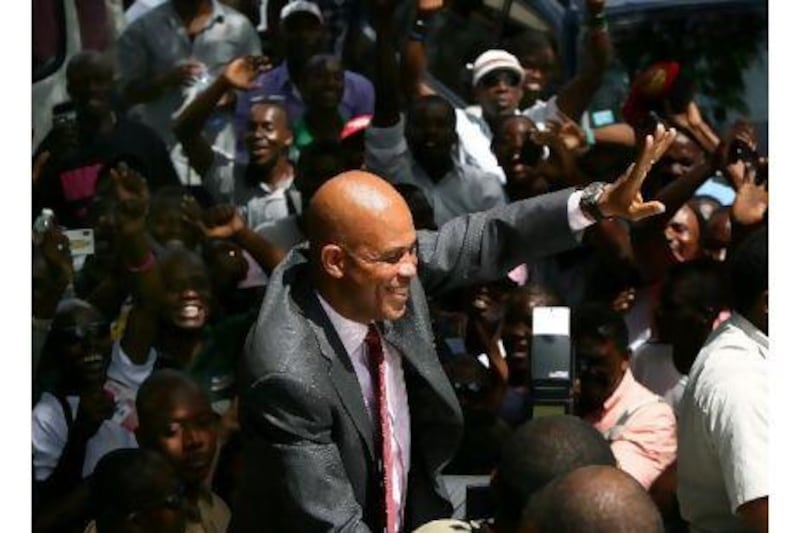 The Haitian president-elect Michel Martelly waves to supporters in Port-au-Prince. He promised voters a 'new era' for Haiti.