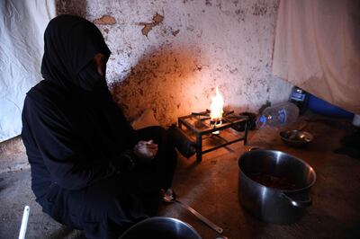 TOPSHOT - Um Samer, a displaced woman from eastern Ghouta, prepares an iftar meal at their home in Maarrat Misrin some seven kilometres north of Idlib on May 26, 2018. 
  / AFP / OMAR HAJ KADOUR
