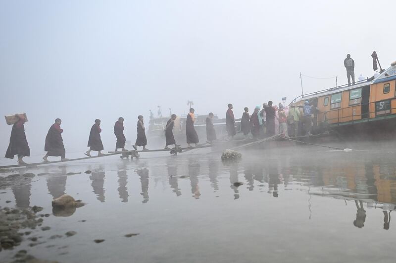 Buddhist monks boarding a boat in Hkamti township in Myanmar's Sagaing region.  AFP