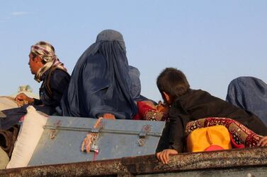 An Afghan woman in a blue burqa sit on the top of a vehicle as after being released by insurgents in the northern province of Sar-i-Pul in 2017. AFP