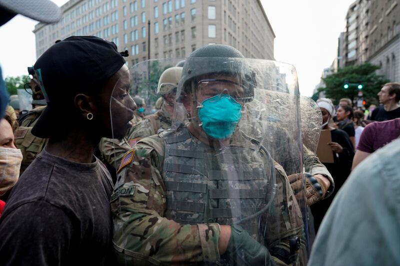 U.S. Army soldiers pass protesters as they arrive to maintain a perimeter during a rally against the death in Minneapolis police custody of George Floyd, near the White House, in Washington, U.S. REUTERS