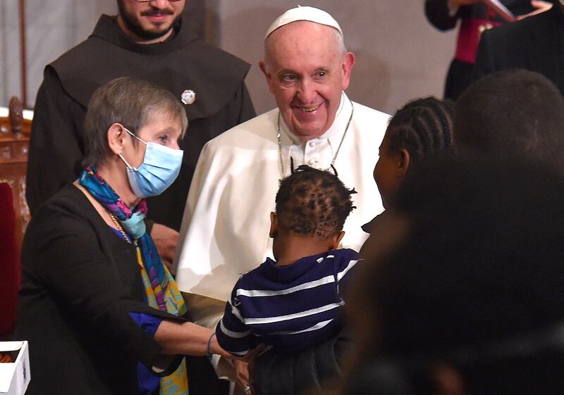 Pope Francis greets a woman holding a child after an ecumenical prayer with migrants. AFP