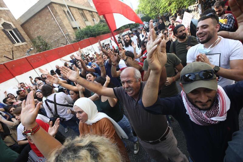 Anti-government protesters shout slogans as they rally outside Lebanon's Central Bank at the same time of a press conference held by the bank's governor in Beirut on November 11, 2019. Lebanon's central bank on said it would strive to maintain the local currency's peg to the US dollar and ease access to the greenback after weeks of mass protests. / AFP / ANWAR AMRO
