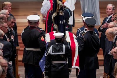 President Donald Trump and former President George Bush watch as the flag-draped casket of former President George H.W. Bush is carried by a military honor guard during a State Funeral at the National Cathedral, Wednesday, Dec. 5, 2018,  in Washington. Andrew Harnik/Pool via REUTERS