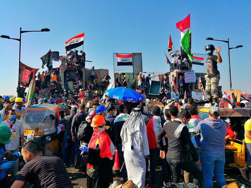 Anti-government protesters control some barriers set by Iraqi security forces to close the bridge leading to the Green Zone during ongoing protests in Baghdad, Iraq, Friday, Nov. 1, 2019. (AP Photo/Khalid Mohammed)