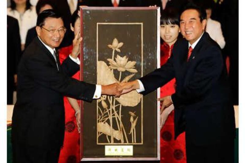 Taiwan's Straits Exchange Foundation Chairman P K Chiang, left, shakes hands with Chen Yunlin, Chairman of China's Association for Relations Across the Taiwan Straits, in front of a gift which Chiang presents Chen after a signing ceremony, in Chongqing, Tuesday June 29, 2010.