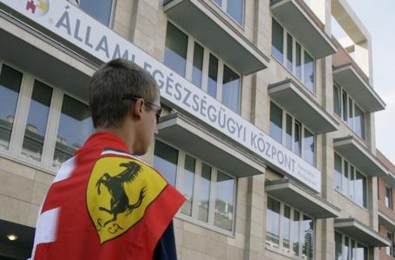 A Ferrari fan waits in front of the hospital of Ferrari driver Felipe Massa in Budapest yesterday. Doctors have said his condition is no longer life threatening.