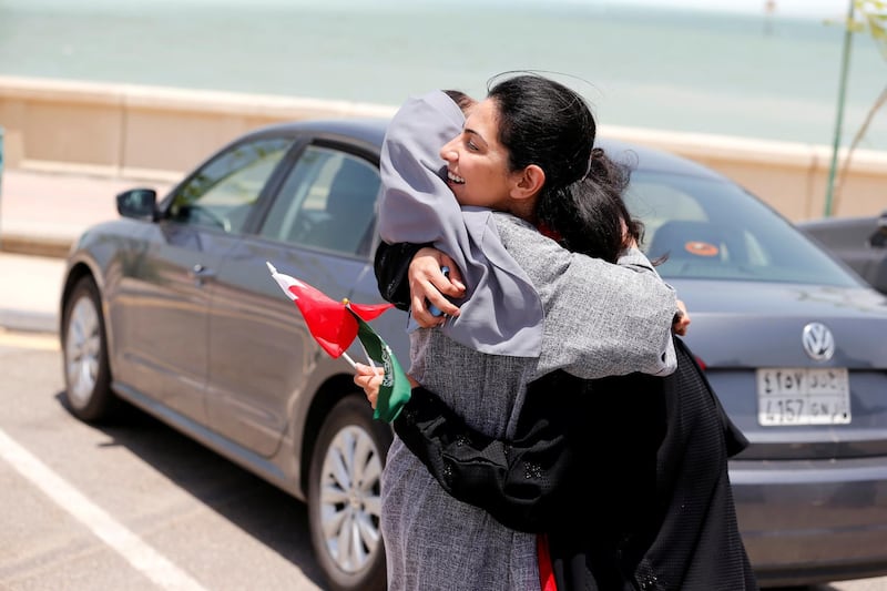 Bahraini Nouf Al Maloud (R) hugs Saudi Zahoor Assiri (L) as they arrive in east Saudi in their cars to promote and congratulate Saudi women on the lifting of the driving ban in Saudi Arabia June 24, 2018. REUTERS/Hamad I Mohammed