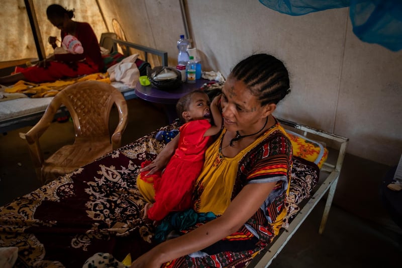 Mother Roman Kidanemariam, 35, holds her malnourished daughter, Merkab Ataklti, 22 months old, in the treatment tent of a medical clinic in the town of Abi Adi, in the Tigray region of northern Ethiopia. AP Photo