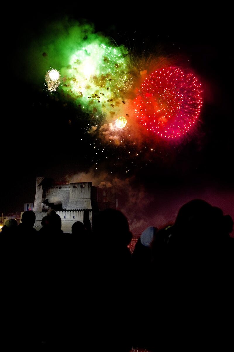 epa03046748 Crowds watch fireworks illuminate the night sky over Castel dell'Ovo in Naples, Italy, 01 January 2012.  EPA/CIRO FUSCO *** Local Caption ***  03046748.jpg
