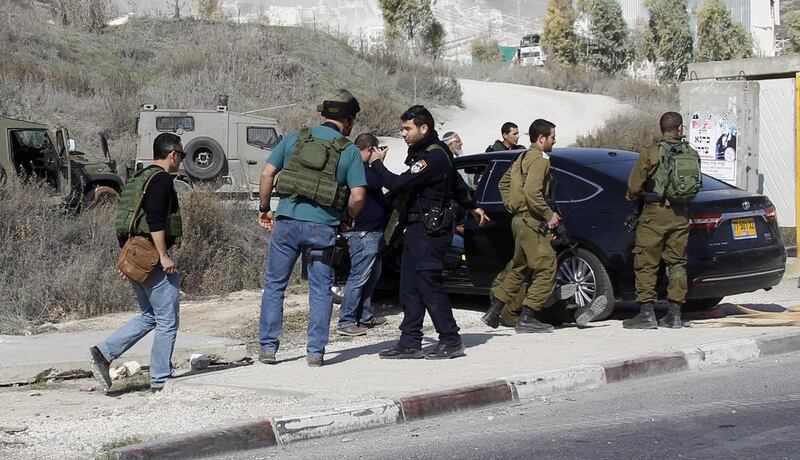 Israeli soldiers and police inspect the damaged car of an Israeli settler who ran over and opened fire on a Palestinian girl near the West Bank city of Nablus on November 22. EPA