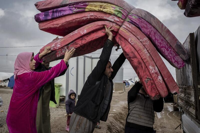 Iraqis load a truck with their possessions at the Khazer camp for internally displaced people before returning home to Mosul on December 26, 2016. Cengiz Yar/AP Photo