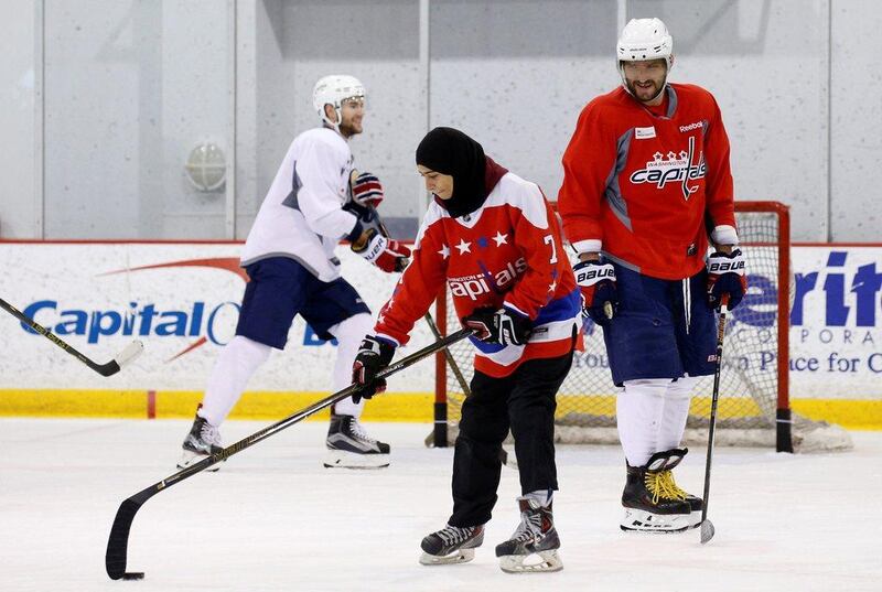 Washington Capitals ice hockey star Alex Ovechkin smiles as Fatima Al Ali from United Arab Emirates skates with the team in Arlington, Virginia, on February 8, 2017. Al Ali's visit coincides with the National Hockey League's "Hockey is for Everyone" month. Kevin Lamarque / Reuters