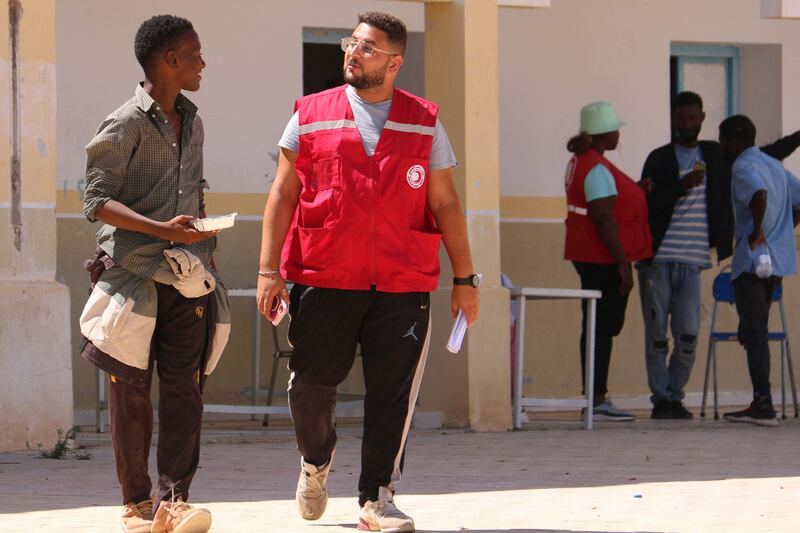 A Tunisian Red Crescent worker speaks to a migrant who fled Sfax. AFP