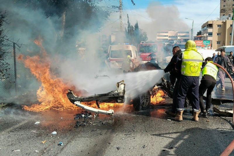 Firefighters douse a burning car after it was hit in a reported Israeli drone attack in south Lebanon. AFP