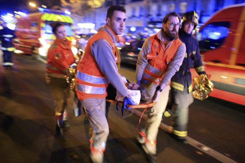 A woman is being evacuated from the Bataclan theatre after a shooting in Paris on November 13, 2015. Thibault Camus/AP Photo